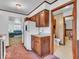 Functional kitchen with white appliances and wood cabinetry, leading to living and bath areas at 66 Coronado Rd, Indianapolis, IN 46234
