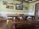 The dining room features a rustic wood table, gallery wall art, and painted green walls at 7211 Kensington Ct, Avon, IN 46123