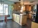 Bright kitchen with wood cabinets, dark countertops, and center island with hanging pendant lights at 7211 Kensington Ct, Avon, IN 46123