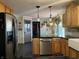 Well-lit kitchen featuring stainless steel appliances, wood cabinets, and modern light fixtures at 7211 Kensington Ct, Avon, IN 46123