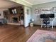 An open-concept living area boasting hardwood floors, a fireplace, built-in shelving, and an adjacent office space at 7211 Kensington Ct, Avon, IN 46123