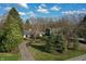 Aerial view of the property featuring a well maintained lawn, mature trees and an asphalt driveway at 7525 N Meridian St, Indianapolis, IN 46260