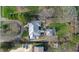 An aerial view showcases the home's unique roofline, lush landscaping, and proximity to mature trees at 7525 N Meridian St, Indianapolis, IN 46260
