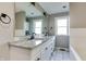 Bathroom features a double sink vanity with granite countertop, large mirror, and white tile flooring at 7525 N Meridian St, Indianapolis, IN 46260
