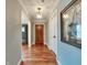 Inviting hallway with hardwood floors, decorative ceiling, and a view of the front door at 7525 N Meridian St, Indianapolis, IN 46260