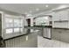 Well-lit kitchen with gray cabinetry, stainless steel appliances, granite countertops, and a view through the window at 7525 N Meridian St, Indianapolis, IN 46260
