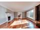 Bright living room with hardwood floors, a fireplace, large window, and decorative molding at 7525 N Meridian St, Indianapolis, IN 46260