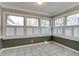 Cozy sun room featuring lots of windows with wood shutters, tiled flooring, and crown moulding at 7525 N Meridian St, Indianapolis, IN 46260