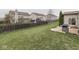 Large, grassy backyard with wooden fence, lovely landscaping, and a stone patio with grill at 7730 Imperial Eagle Dr, Zionsville, IN 46077