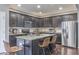 Well-lit kitchen featuring stainless steel appliances, dark cabinets, and a granite-topped island with bar stools at 7730 Imperial Eagle Dr, Zionsville, IN 46077