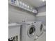 Well-equipped laundry room with modern washer and dryer, utility sink, and ample shelving for storage at 7730 Imperial Eagle Dr, Zionsville, IN 46077