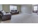 Carpeted living room featuring two leather sofas, neutral walls, and window with blinds at 7730 Imperial Eagle Dr, Zionsville, IN 46077