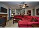 Spacious living room featuring plush red sofa, ceiling fan, and staircase at 8358 Balmoral Dr, Avon, IN 46123