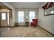 Bright living room with neutral carpet, a red accent chair, and a view of the front door at 8358 Balmoral Dr, Avon, IN 46123