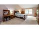 Comfortable bedroom with a vaulted ceiling, a large window, and a wooden sleigh bed complemented by side tables and lamps at 8737 Champions Dr, Indianapolis, IN 46256