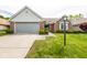 Charming brick home with a well-maintained lawn and attached two-car garage, complemented by a classic-style lamp post at 8737 Champions Dr, Indianapolis, IN 46256
