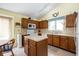 Kitchen with wooden cabinetry, light countertops, central island, and modern appliances, offering a functional workspace at 8737 Champions Dr, Indianapolis, IN 46256
