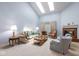 Bright living room with vaulted ceiling, skylights, a fireplace, and comfortable seating arrangements at 8737 Champions Dr, Indianapolis, IN 46256