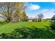 Large backyard with lush lawn and mature trees under a bright blue sky at 901 W 250 N, Lebanon, IN 46052