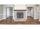 Living room with brick fireplace and views into kitchen with modern white appliances at 901 W 250 N, Lebanon, IN 46052