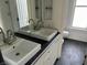 Bathroom with double sinks, white cabinets, and black countertops at 902 N Broadway St, Indianapolis, IN 46202