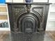 Ornate fireplace detailed with unique metalwork and patterns, set against a tile floor and white built-in shelves at 902 N Broadway St, Indianapolis, IN 46202
