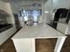 Spacious kitchen with a large marble island, stainless steel appliances, white cabinetry, and hardwood floors at 902 N Broadway St, Indianapolis, IN 46202