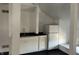 Compact kitchenette featuring white cabinets, black countertop and a refrigerator at 902 N Broadway St, Indianapolis, IN 46202