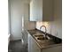 Laundry room with front loading washer and dryer and stainless sink at 902 N Broadway St, Indianapolis, IN 46202