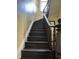 Elegant staircase featuring dark wood steps and handrail, complemented by a white trim and textured wall at 902 N Broadway St, Indianapolis, IN 46202