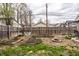 Large backyard featuring garden beds, a fire pit, a white bistro set, all bordered by a wooden privacy fence at 902 Villa Ave, Indianapolis, IN 46203