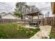 Serene backyard featuring a cozy pergola with seating and a charming garden area bordered by a wooden fence at 902 Villa Ave, Indianapolis, IN 46203