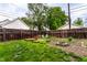 Spacious backyard featuring a wooden fence, small garden, fire pit and open green space at 902 Villa Ave, Indianapolis, IN 46203