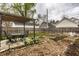 Spacious backyard with a pergola-covered seating area, raised garden beds, a charming fire pit, and a white chair at 902 Villa Ave, Indianapolis, IN 46203
