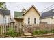 Quaint front exterior featuring a peaked roof, picket fence and garden beds with tulips at 902 Villa Ave, Indianapolis, IN 46203