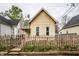 Charming exterior featuring a peaked roof, picket fence and garden beds with tulips at 902 Villa Ave, Indianapolis, IN 46203