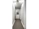 Hallway view with gray tile flooring, white walls, and a door with glass panels leading to another room at 902 Villa Ave, Indianapolis, IN 46203