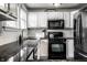 Bright kitchen with black appliances, granite countertops, and white cabinets at 902 Villa Ave, Indianapolis, IN 46203