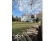 Expansive backyard with lush green lawn, a trampoline, and a pile of firewood, perfect for outdoor activities at 9235 Thrushwood Ln, Indianapolis, IN 46250