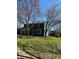 Residential exterior with blue siding, featuring a well-manicured lawn and mature trees on a sunny day at 9235 Thrushwood Ln, Indianapolis, IN 46250