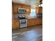 Modern kitchen featuring stainless steel appliances, wooden cabinets, and tiled backsplash at 9235 Thrushwood Ln, Indianapolis, IN 46250