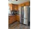 Spacious kitchen boasting stainless steel refrigerator and classic wooden cabinetry at 9235 Thrushwood Ln, Indianapolis, IN 46250