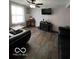 Inviting living room featuring wood-look flooring, a ceiling fan, and a flat-screen TV at 9235 Thrushwood Ln, Indianapolis, IN 46250
