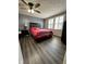 Spacious main bedroom with hardwood floors, ceiling fan, and multiple windows with blinds at 9235 Thrushwood Ln, Indianapolis, IN 46250