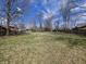 Expansive backyard surrounded by mature trees and a wooden fence, offering ample space at 930 Charlene Ln, Anderson, IN 46011