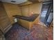Finished basement with a long bar, colorful carpet, and wood walls at 930 Charlene Ln, Anderson, IN 46011