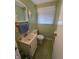Compact bathroom with green patterned wallpaper, classic vanity, and natural light at 930 Charlene Ln, Anderson, IN 46011