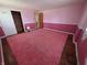 Bedroom with pink walls and carpet, showcasing hardwood floors and a closet at 930 Charlene Ln, Anderson, IN 46011