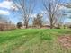 Expansive backyard featuring lush green lawn, mature trees, and a storage shed at 9406 Northeastern Ave, Indianapolis, IN 46239