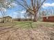 Large backyard featuring mature trees, a storage shed, and a swing at 9406 Northeastern Ave, Indianapolis, IN 46239